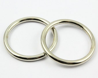 May include: Two silver metal key rings, one slightly larger than the other, are interlocked.