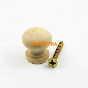 Puede incluir: Un pomo de madera clara con la parte superior redonda y una base ligeramente elevada. El pomo viene con un tornillo de color dorado.