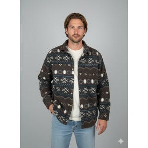 Puede incluir: Una camisa abotonada con un estampado geométrico en marrón, blanco y azul. Se lleva sobre una camiseta blanca y con vaqueros azul claro. La camisa tiene cuello y mangas largas. Conjunto informal.