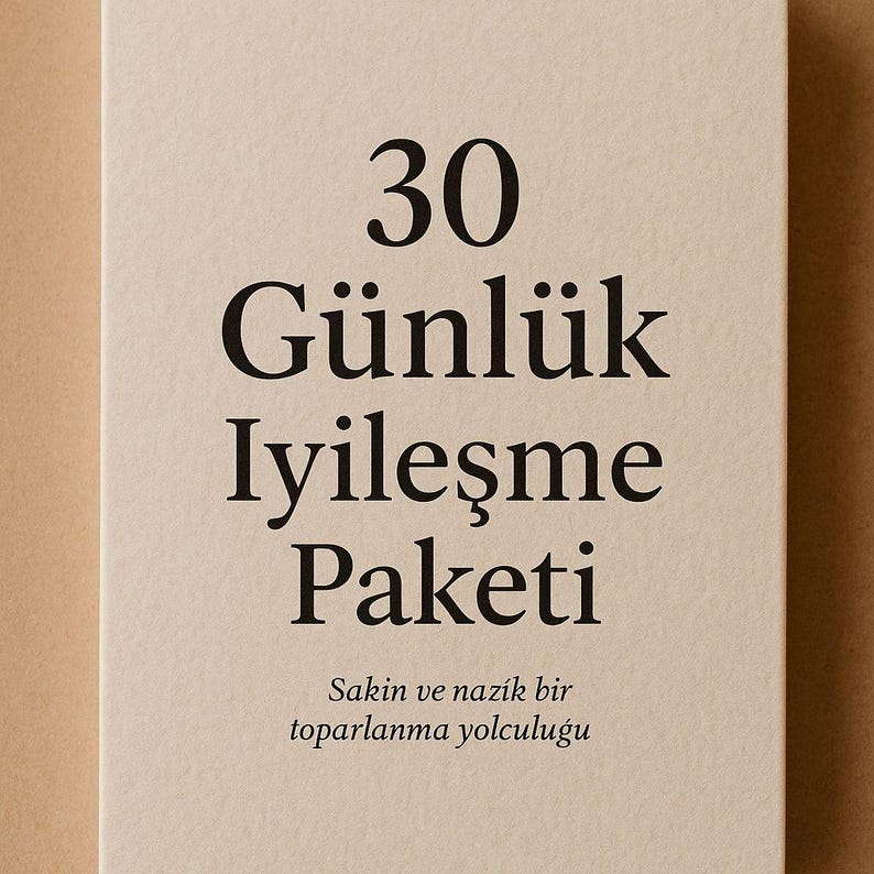 May include: A beige card with black text. The text reads "30 G&uuml;nl&uuml;k İyileşme Paketi" and "Sakin ve nazik bir toparlanma yolculuğu". The card has a simple, minimalist design.
