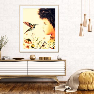 May include: A framed watercolour print showing a woman's profile and a hummingbird. The artwork includes colourful flowers and butterflies. The print is displayed above a wooden cabinet with decorative items.