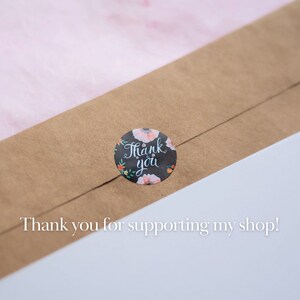 May include: A brown paper envelope with a round sticker that says "Thank you" in white script with floral accents. The text "Thank you for supporting my shop!" is printed below the sticker.