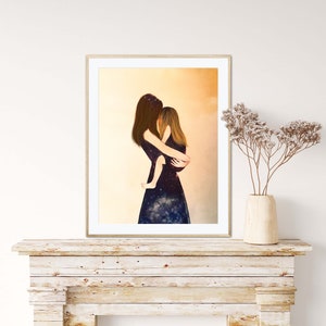 May include: A framed print of a painting depicting a woman holding a child. The woman and child are wearing dark blue dresses with a galaxy print. The background is a soft yellow.