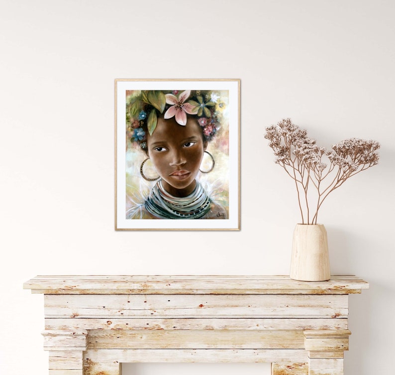 May include: A framed painting of a young woman with dark skin, wearing a flower crown and a beaded necklace. The woman has a soft expression and is looking directly at the viewer.