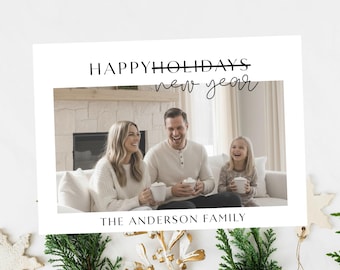 Pode incluir: Cartão de Natal com uma foto de família sorrindo e segurando canecas. O texto "Happy Holidays New Year" e "The Anderson Family" está escrito em preto. O cartão é decorado com vegetação e um floco de neve dourado.