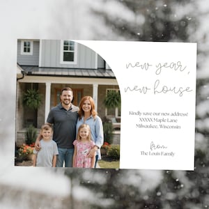 May include: A family portrait in front of a house, with the text "new year, new house." The card includes the new address and the family name. The family consists of two adults and two children.