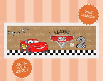 May include: A rectangular banner featuring a red cartoon race car with the text "KA-CHOW!" and "NAME IS 2". The banner includes a checkered flag design and a small banner with black and white flags.