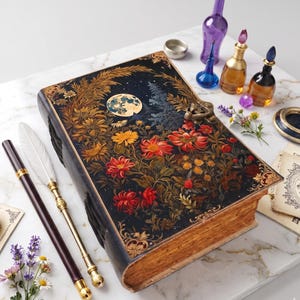 May include: A rectangular book with a black cover featuring a moon and floral illustration in gold, red, and orange. Beside it are a white feather quill, a dark pen, small glass bottles with colored liquids, and sprigs of lavender and daisies.