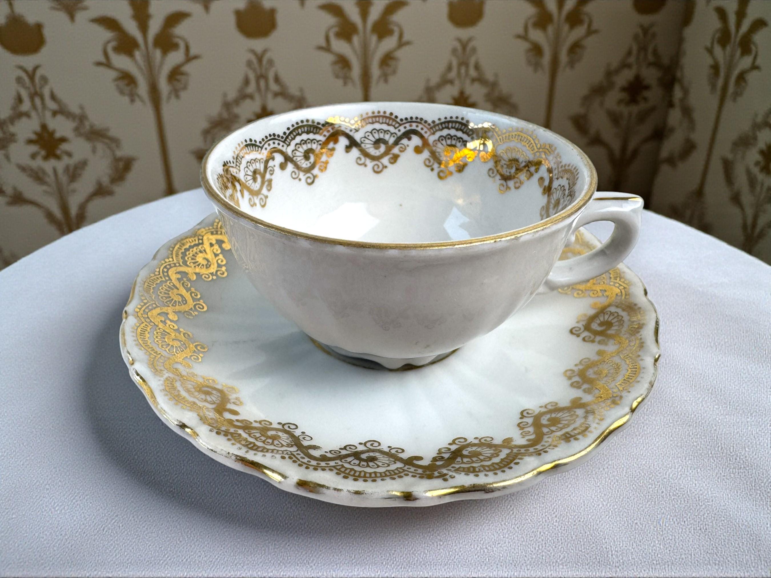 Tasse ancienne en porcelaine allemande sur pied fleurie et dorée et son assiette à gâteau Bavaria