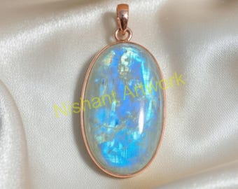 May include: Oval-shaped pendant with a large, iridescent moonstone. The stone has blue and white hues and is set in a rose gold-colored metal frame. The pendant hangs from a matching bail.