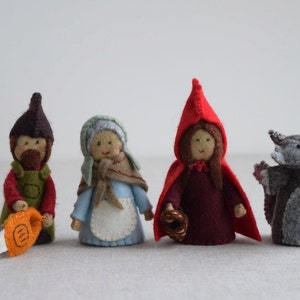 May include: Set of four felt finger puppets depicting characters from the fairy tale Little Red Riding Hood. The puppets include a woodcutter, a grandmother, Little Red Riding Hood, and a wolf.