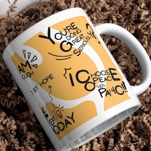 Op de afbeelding: Witte keramische mok met een gebogen handvat, met zwarte en gele tekst. De tekst bevat zinnen als "You're doing great, seriously?" en "Choose peace over panic!" De mok staat in een bruin papier gevulde doos.