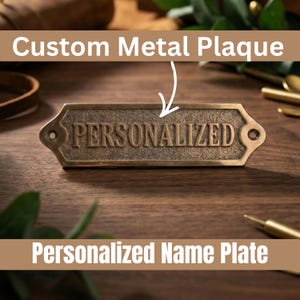 Op de afbeelding: Een bronzen metalen plaat met het woord "PERSONALIZED" in reliëf. De plaat heeft een rechthoekige vorm met decoratieve randen en montagegaten. De tekst "Custom Metal Plaque" en "Personalized Name Plate" zijn ook zichtbaar.