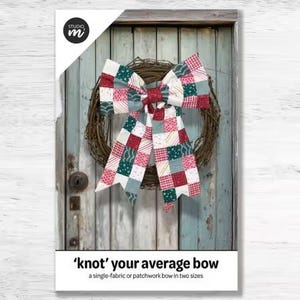 May include: A colorful patchwork bow with red, white, and green squares is centered on a natural twig wreath. The bow is displayed against a weathered, light blue wooden door. The text reads "'knot' your average bow".