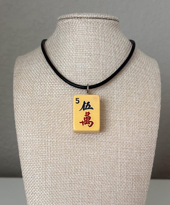 A real vintage mahjong tile turned into a sterling silver necklace — wearable nostalgia with genuine game-piece provenance and serious conversation-starter energy.