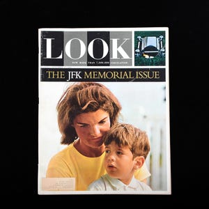 Pode incluir: Uma edição vintage da revista Look, "The JFK Memorial Issue", com uma fotografia de uma mulher e um menino. A capa da revista apresenta a palavra "LOOK" em letras grandes, com texto adicional acima e abaixo do título.