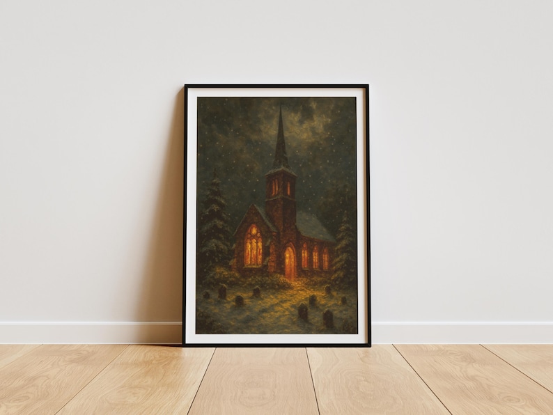 Peut inclure: Impression d'art encadr&eacute;e d'une &eacute;glise la nuit. L'&eacute;glise est en briques rouge fonc&eacute; avec un haut clocher et des fen&ecirc;tres &eacute;clair&eacute;es. La neige tombe autour de l'&eacute;glise et du cimeti&egrave;re au premier plan. L'impression est dans un cadre noir et est affich&eacute;e sur un mur blanc.