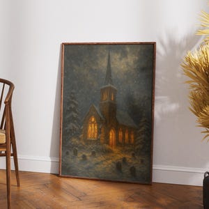 Peut inclure: Une impression d'art encadr&eacute;e repr&eacute;sente une &eacute;glise la nuit, &eacute;clair&eacute;e de l'int&eacute;rieur. L'&oelig;uvre pr&eacute;sente un ciel sombre et neigeux et un cimeti&egrave;re au premier plan. L'&eacute;glise a un haut clocher et est entour&eacute;e de conif&egrave;res.