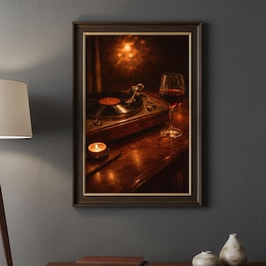 May include: A framed picture shows a vintage record player with a vinyl record, a lit candle, and a glass of red wine. The scene is set on a wooden surface, creating a warm atmosphere. The image is framed in a dark brown frame.