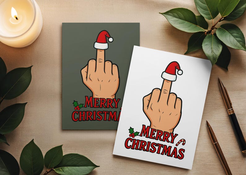 以下が含まれることがあります： サンタ帽をかぶった中指を立てた手のクリスマスカードが2枚。カードには赤い文字で「MERRY CHRISTMAS」と書かれています。1枚は緑色の背景、もう1枚は白い背景です。