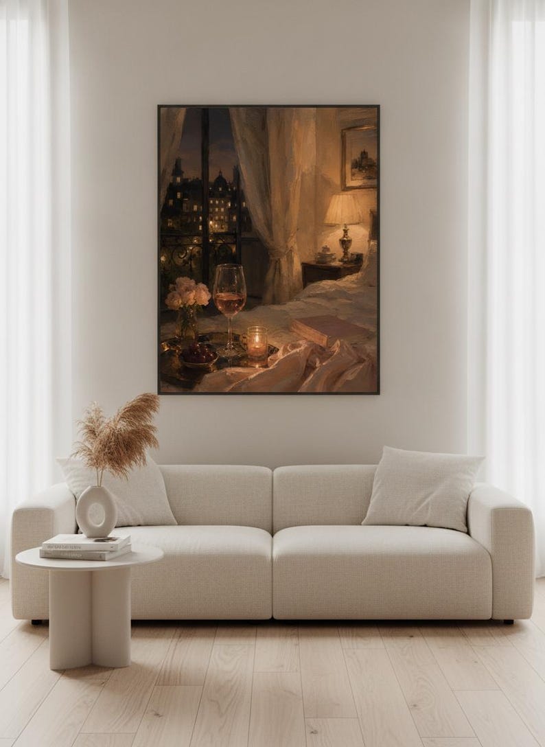 May include: A framed wall art print depicting a cozy bedroom scene at night with a glass of wine, a small vase of flowers, a candle, and an open book on a bed, set against a window view of a city skyline with warm indoor lamp lighting.