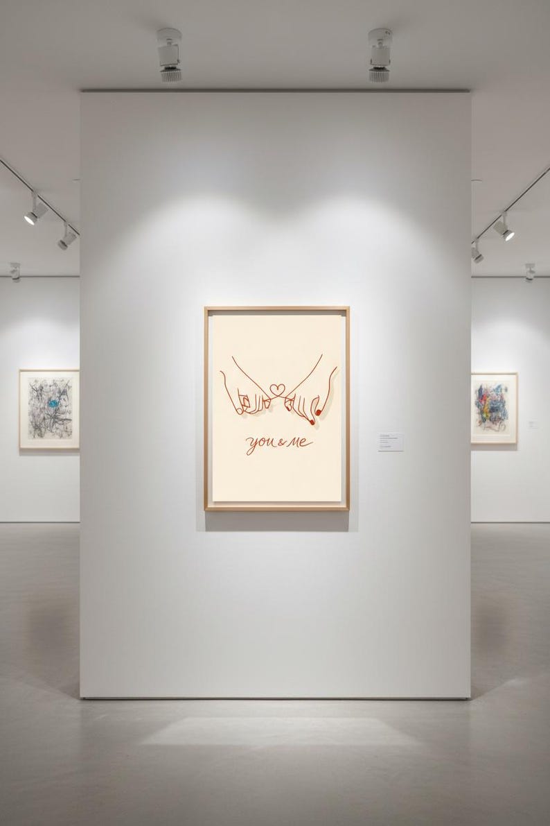 Puede incluir: Impresi&oacute;n art&iacute;stica enmarcada con una ilustraci&oacute;n minimalista de dos manos entrelazando los me&ntilde;iques, con un coraz&oacute;n y las palabras "you & me" en cursiva. La obra de arte se exhibe en una galer&iacute;a con otras piezas enmarcadas.