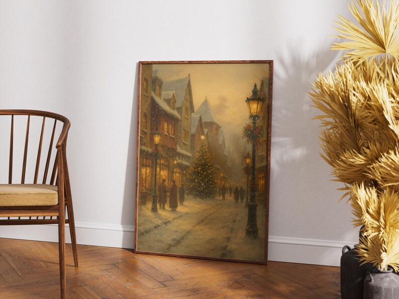 May include: Framed vintage painting of a snowy European street scene at dusk. The artwork depicts a Christmas tree, street lamps, and figures walking along a snow-covered road. The painting has a warm, inviting color palette.