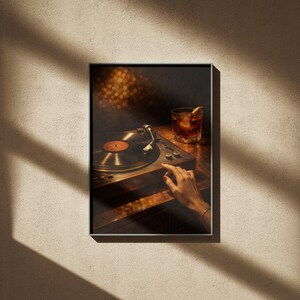 May include: Framed print of a vintage record player with a vinyl record. A hand is reaching towards the controls. A cocktail with an orange slice sits nearby. The image has a warm aesthetic, with soft lighting and a dark background.