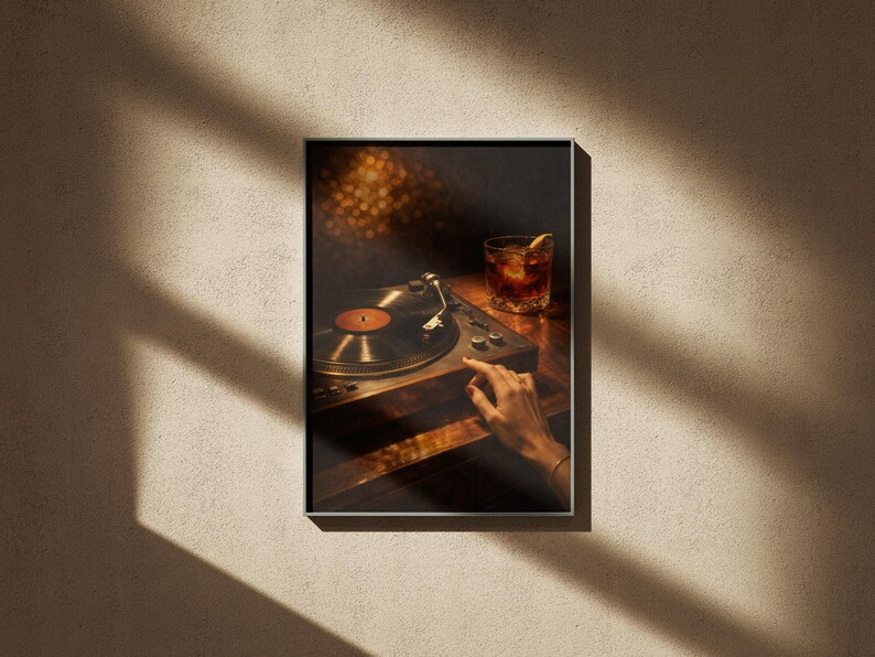 May include: Framed print of a vintage record player with a vinyl record. A hand is reaching towards the controls. A cocktail with an orange slice sits nearby. The image has a warm aesthetic, with soft lighting and a dark background.