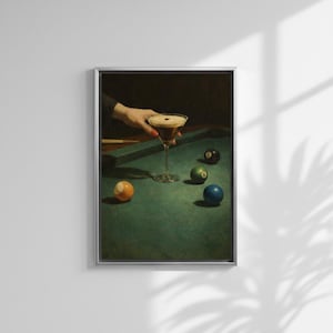 Puede incluir: Impresi&oacute;n enmarcada de un c&oacute;ctel sobre una mesa de billar con bolas. Una mano sostiene la copa de martini con una bebida oscura y espuma. La mesa de billar es verde y las bolas son de varios colores.