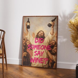 A framed funny altered art poster of Jesus holding two wine bottles with the neon pink text 'Did Someone Say Wine?', perfect for eclectic kitchen or home bar decor.
