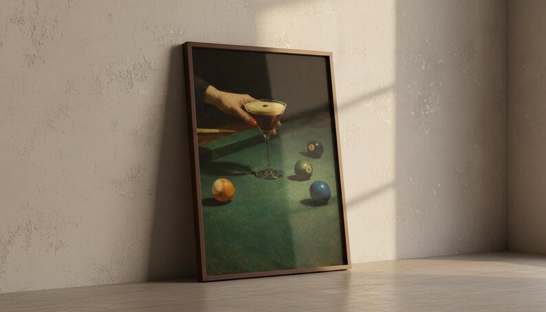 Puede incluir: Impresi&oacute;n enmarcada de una escena de naturaleza muerta con una copa de martini y bolas de billar sobre una mesa de fieltro verde. La obra de arte tiene una est&eacute;tica vintage, con una mano sosteniendo el c&oacute;ctel. Las bolas son de varios colores, incluyendo naranja, verde y azul.