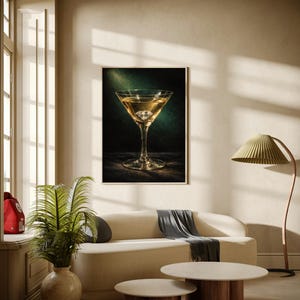 Puede incluir: Una impresi&oacute;n enmarcada de un c&oacute;ctel en una copa de martini. La bebida es dorada, con un cubito de hielo transparente. La impresi&oacute;n cuelga sobre un sof&aacute; color crema con una manta gris. Dos mesas de centro redondas con bases de madera est&aacute;n frente al sof&aacute;.
