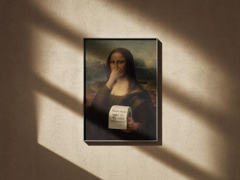 May include: Framed print of the Mona Lisa holding a roll of toilet paper with the text "Please remain seated for the entire performance." The artwork is set against a neutral wall with shadows.
