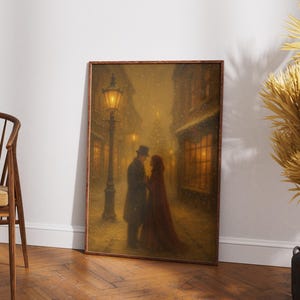 May include: A framed print showing a couple in a snowy street scene. The man wears a coat and top hat, the woman a red cloak. A lamppost illuminates the scene, with buildings and lit windows in the background.