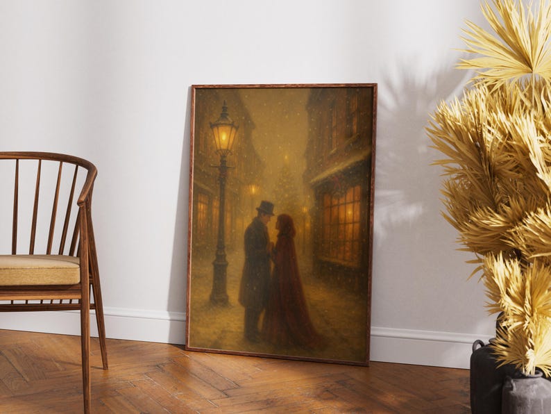 May include: A framed print showing a couple in a snowy street scene. The man wears a coat and top hat, the woman a red cloak. A lamppost illuminates the scene, with buildings and lit windows in the background.