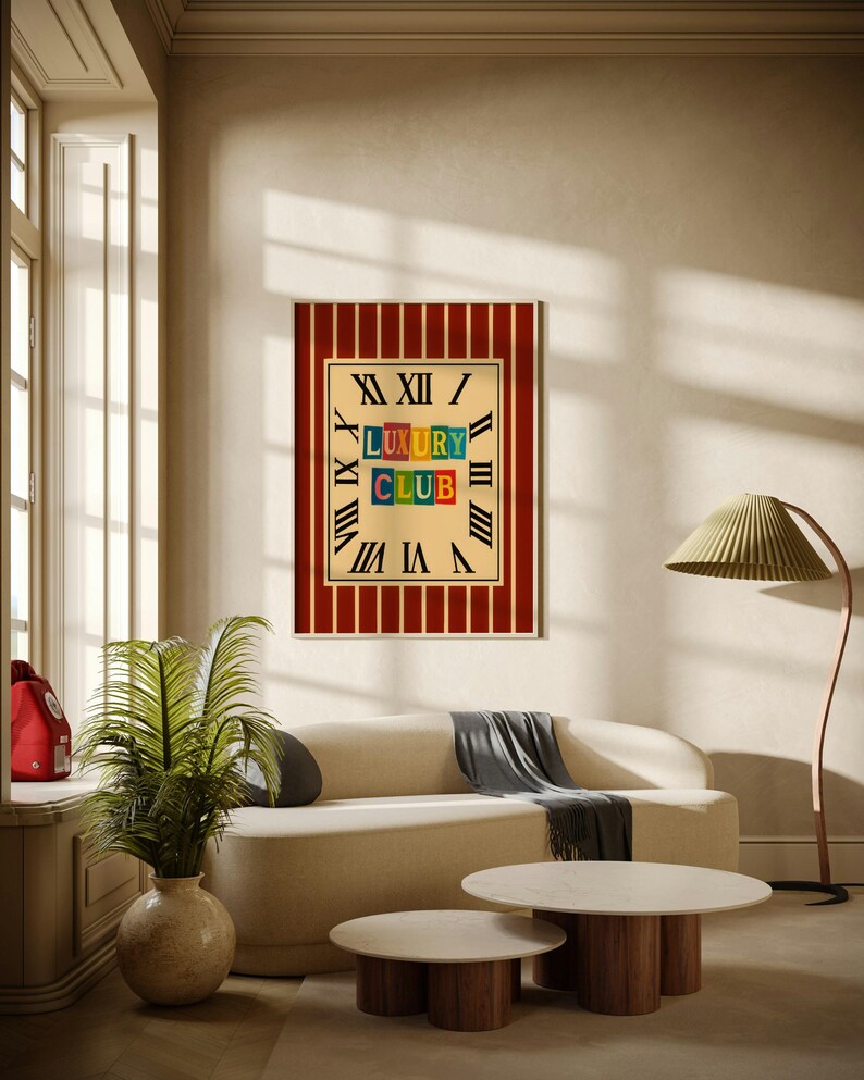 Pu&ograve; includere: Un'opera d'arte incorniciata con uno sfondo a strisce rosse e crema e le parole "LUXURY CLUB" in lettere colorate. L'opera d'arte si trova in una stanza con un divano color crema, due tavolini rotondi e una lampada da terra.