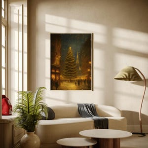 May include: A framed print of a Christmas scene in a city street, featuring a decorated tree and the Eiffel Tower. The print hangs above a cream-colored sofa with a gray throw, and two round coffee tables with wooden legs. A green plant in a beige vase sits nearby.