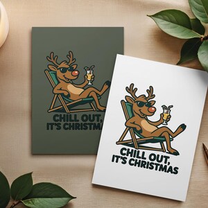 Pu&ograve; includere: Due biglietti di Natale con una renna dei cartoni animati con occhiali da sole, che si rilassa su una sedia a sdraio e tiene in mano un cocktail. Le carte riportano la scritta "Chill Out, It's Christmas". Un biglietto &egrave; verde, l'altro &egrave; bianco.