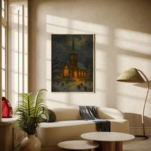 Peut inclure: Tableau encadr&eacute; d'une &eacute;glise la nuit, &eacute;clair&eacute;e par une lumi&egrave;re chaleureuse, avec de la neige qui tombe. L'&oelig;uvre est suspendue au-dessus d'un canap&eacute; cr&egrave;me avec un plaid gris. Deux tables basses rondes avec des bases en bois sont devant le canap&eacute;.