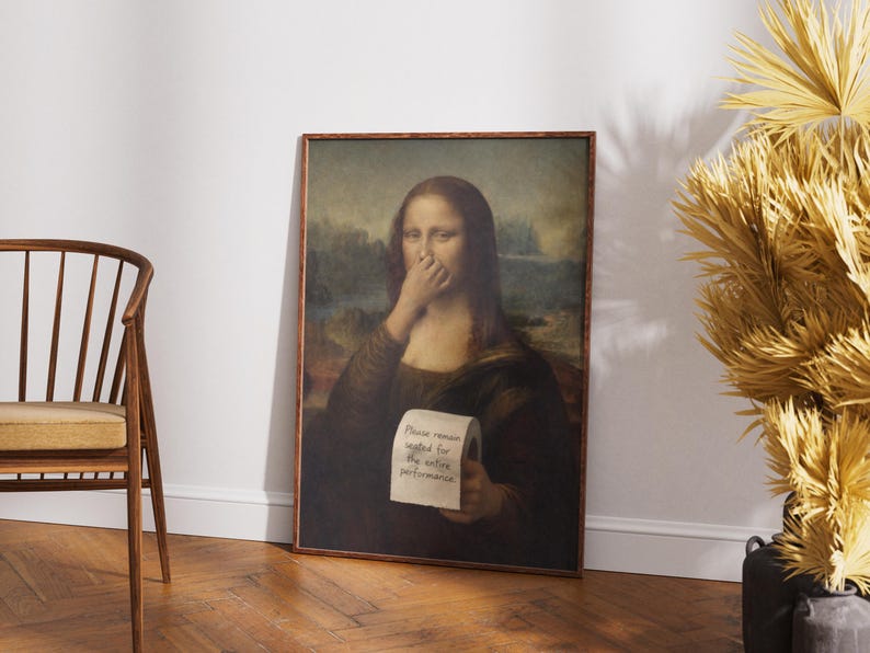 May include: A framed print of the Mona Lisa with a humorous twist. The iconic figure covers her nose with her hand and holds a roll of toilet paper with the text "Please remain seated for the entire performance."