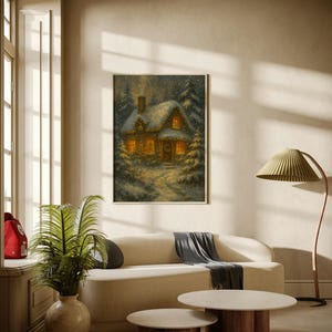 K&ouml;nnte beinhalten: Ein gerahmtes Winterlandschaftsbild zeigt ein gem&uuml;tliches Cottage mit beleuchteten Fenstern, umgeben von schneebedeckten B&auml;umen. Das Kunstwerk h&auml;ngt &uuml;ber einem cremefarbenen Sofa mit einem grauen &Uuml;berwurf.