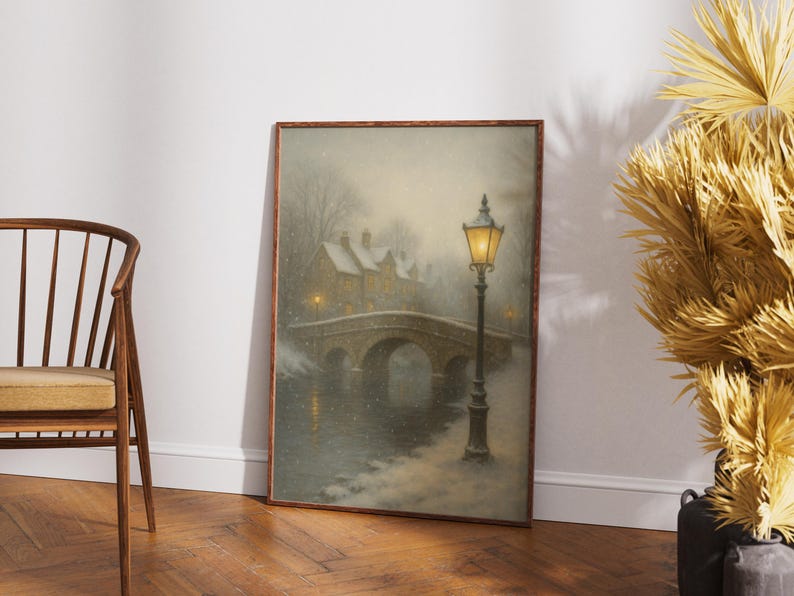 May include: Framed art print depicting a winter scene with a stone bridge, snow-covered buildings, and a glowing street lamp. The artwork has a vintage, painterly style, with soft colors and a serene atmosphere. The bridge arches over a body of water.