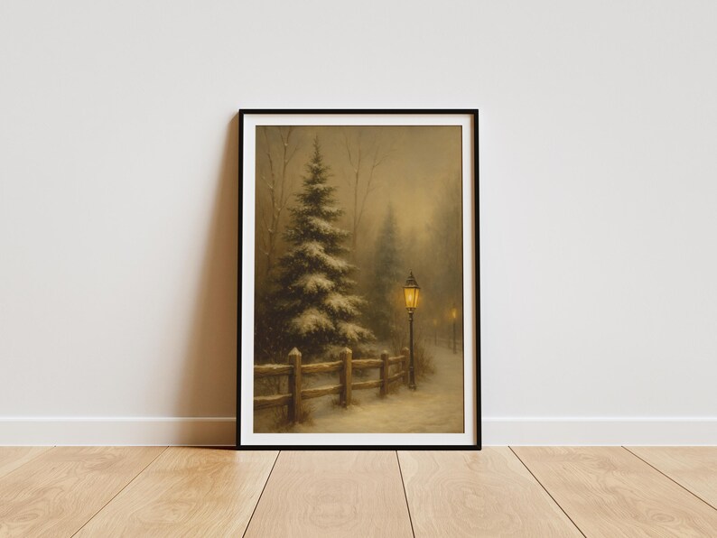 May include: Framed winter landscape art print. The artwork depicts a snow-covered path with a wooden fence, evergreen trees, and a glowing lamppost. The scene is set in a misty, muted color palette, evoking a serene, cold atmosphere.