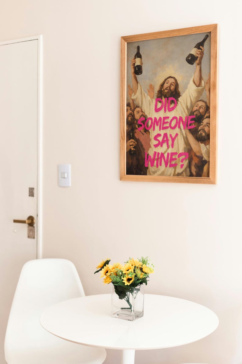 A framed funny altered art poster of Jesus holding two wine bottles with the neon pink text 'Did Someone Say Wine?', perfect for eclectic kitchen or home bar decor.