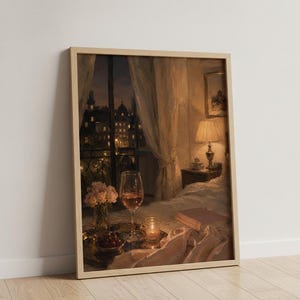 May include: A framed art print depicting a cozy bedroom interior at night. A bedside lamp illuminates a book, a glass of rose wine, a small vase of pink flowers, and a candle on a tray. A window reveals a dark city skyline with glowing lights.