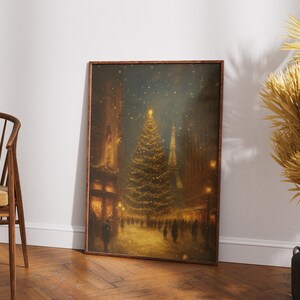 May include: A framed print depicts a nighttime Christmas scene. A large, illuminated Christmas tree stands in the center of a snowy street, surrounded by buildings and figures. The artwork is in warm tones, with a focus on the tree's lights.