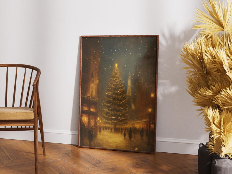 May include: A framed print depicts a nighttime Christmas scene. A large, illuminated Christmas tree stands in the center of a snowy street, surrounded by buildings and figures. The artwork is in warm tones, with a focus on the tree's lights.