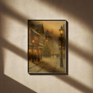 May include: Framed print of a winter scene depicting a snow-covered street lined with buildings and lit by street lamps. A Christmas tree stands in the center, with figures of people walking along the street. The artwork has a warm, inviting color palette.