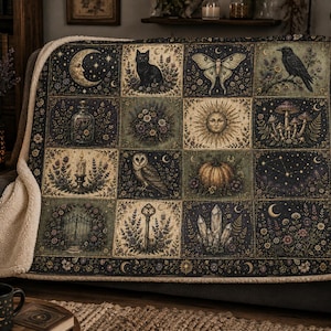 May include: A rectangular throw blanket with a sherpa fleece lining, featuring a grid of twelve square illustrations including a crescent moon, black cat, moth, raven, bottle, flowers, sun, mushrooms, candle, owl, pumpkin, and crystals.